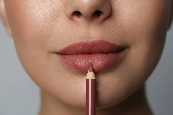 Jeune Femme Appliquant Beau Crayon Lèvres Sur Fond Gris Gros — Photo