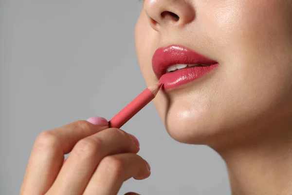 Jeune Femme Appliquant Beau Crayon Lèvres Rose Sur Fond Gris — Photo