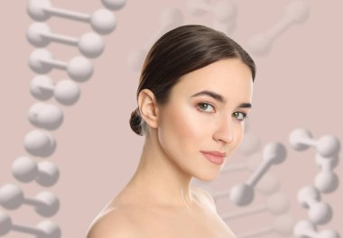 Güzel genç bir kadın bej arka planda DNA zincirlerinin resimleriyle