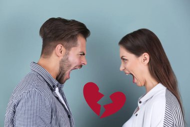 Genç bir çift renk arka planında tartışırken ve kırık kalp örnekleri çizerken. İlişki sorunları