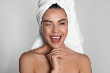 Kafasında havluyla arka planda güzel bir kadın.