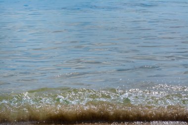Arka planda dalgalar olan güzel deniz suyu yüzeyi, yakın plan.