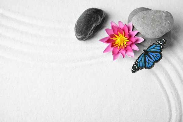 美丽的蝴蝶 花朵和石头点缀在白沙滩上 花纹斑斑 禅的概念 — 图库照片