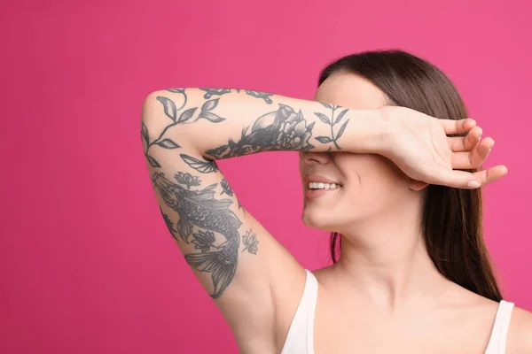 Vacker Kvinna Med Tatueringar Armen Mot Rosa Bakgrund — Stockfoto