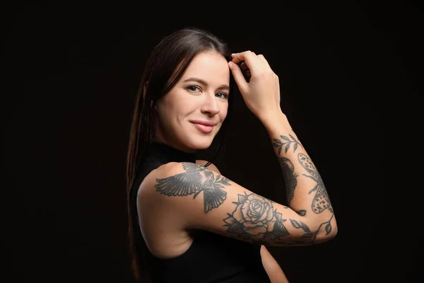 Vacker Kvinna Med Tatueringar Armen Mot Svart Bakgrund — Stockfoto