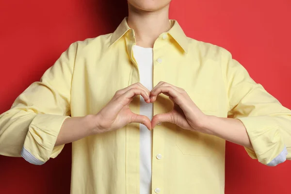Vrouw Maken Hart Met Handen Rode Achtergrond Closeup — Stockfoto