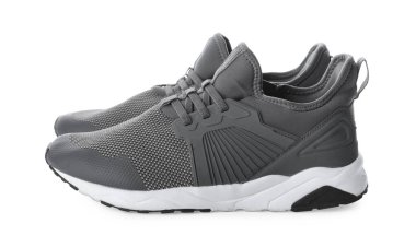 Beyaz arka planda bir çift şık gri spor ayakkabı.