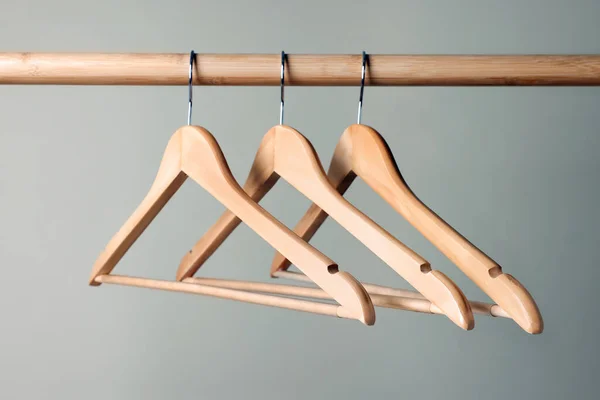 Kleiderbügel Auf Holzgeländer Vor Beigem Hintergrund — Stockfoto