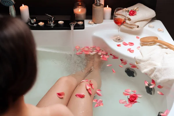 バラの花びらでお風呂に入る女性 閉じます ロマンチックな雰囲気 — ストック写真