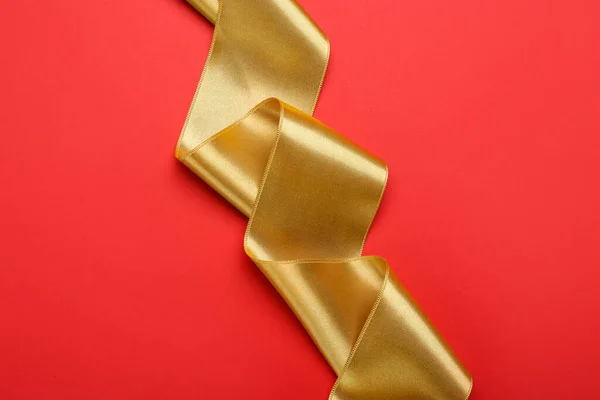 赤い背景の美しい黄金のリボン トップビュー — ストック写真