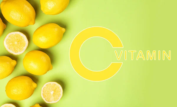 Source of Vitamin C. Flat lay composition with whole and sliced lemons on green background