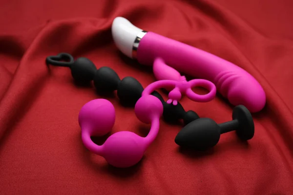 Pinkfarbenes Und Schwarzes Sexspielzeug Auf Rotem Stoff — Stockfoto