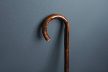 Gri arka planda zarif tahta baston, yakın plan.