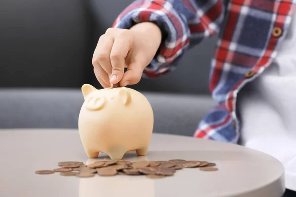 Kleiner Junge Steckt Münze Sparschwein Tisch Drinnen Nahaufnahme — Stockfoto