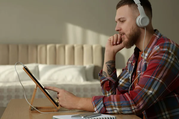 Online test. Man studying with tablet at home