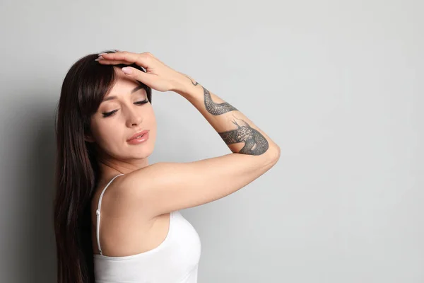 Mulher Bonita Com Tatuagens Braço Contra Fundo Cinza Espaço Para — Fotografia de Stock