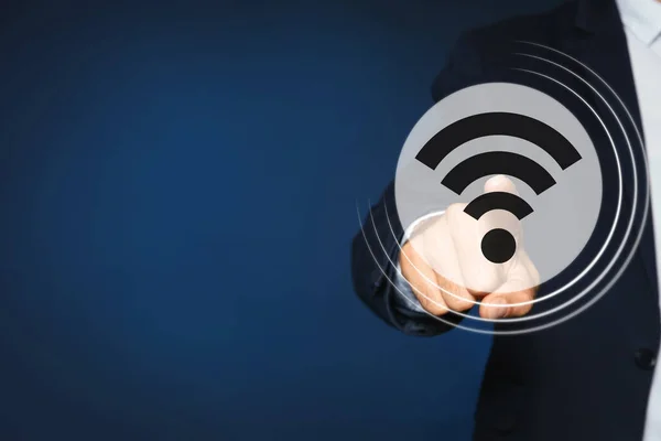 暗い青の背景にデジタル画面上のWi Fiシンボルに触れる男 クローズアップ — ストック写真