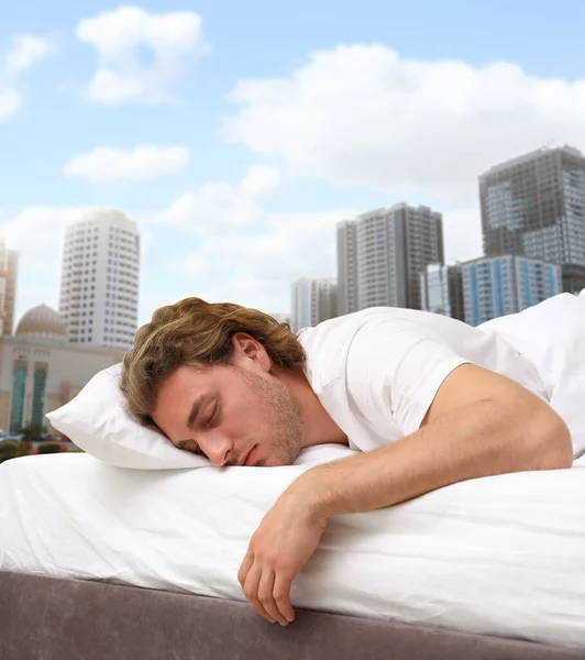 남자는 침대에서 아름다운 배경에 도시의 — 스톡 사진