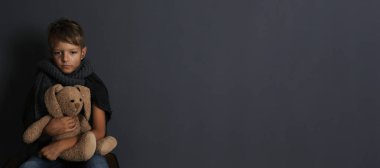 Zavallı çocuk arka planda oyuncak tavşanla oturuyor, mesaj için yer var. Pankart tasarımı