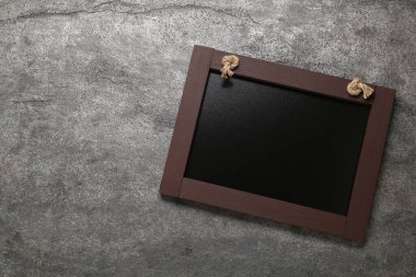 Gri masadaki temiz, küçük siyah karatahta, üst manzara. Metin için boşluk