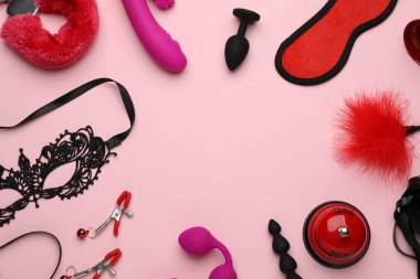 Pembe arka planda seks oyuncakları ve aksesuarların çerçevesi. Metin için boşluk
