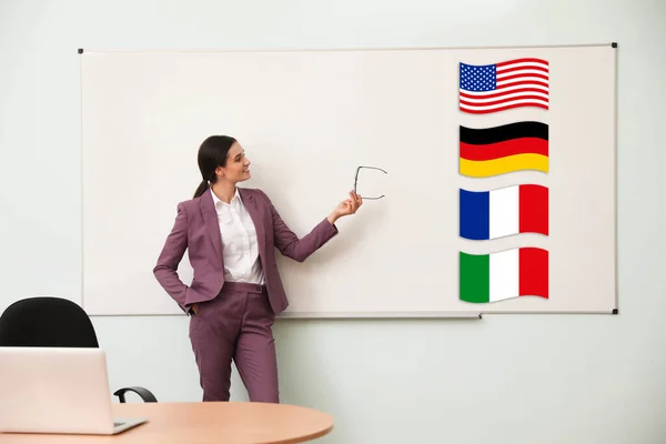 Profesor Idiomas Extranjeros Cerca Pizarra Blanca Con Diferentes Banderas Aula —  Fotos de Stock