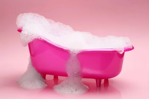 Toy Fürdőkád Túlcsorduló Hab Rózsaszín Háttér — Stock Fotó