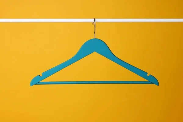 Leere Kleiderbügel Auf Metallschiene Vor Gelbem Hintergrund — Stockfoto