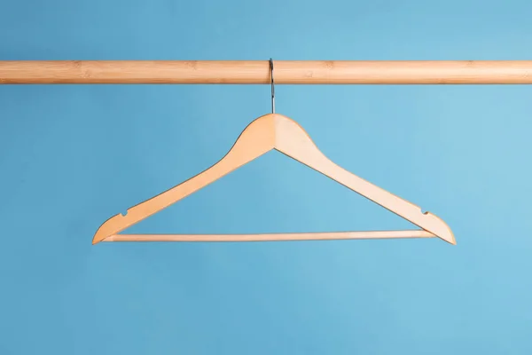 Empty Clothes Hanger Wooden Rail Light Blue Background — Stock Photo, Image