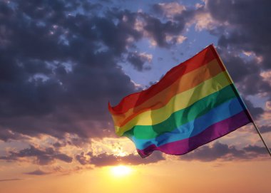 Gün batımında gökyüzüne karşı parlak gökkuşağı LGBT bayrağı