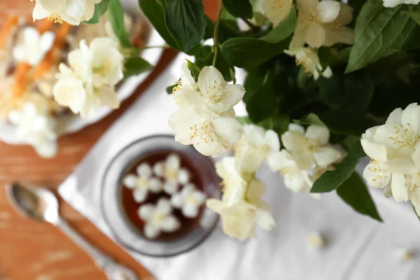 Branch of jasmine plant with beautiful white flowers on blurred background, top view. Space for text