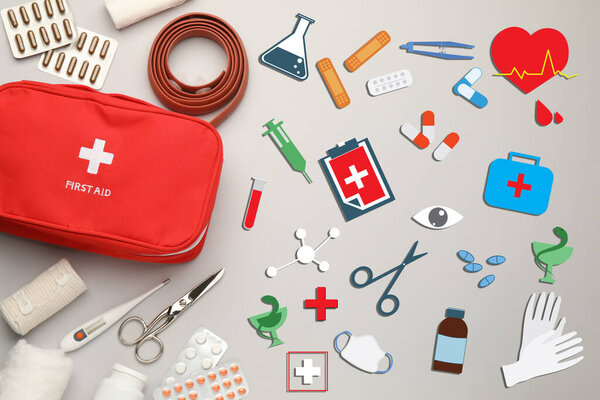 First aid kit and different images on light grey background, flat lay