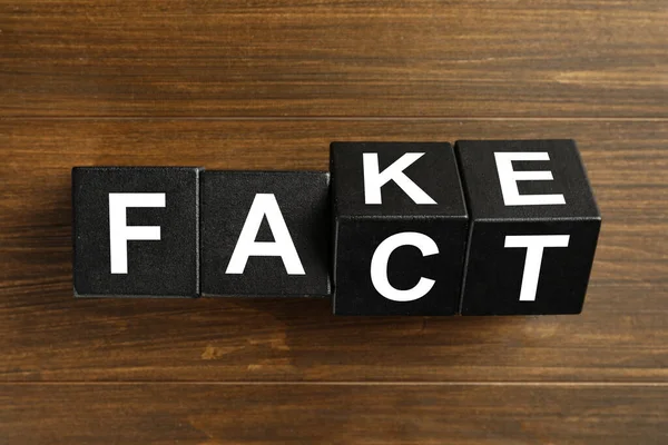 Palavras Fake Fact Feito Com Cubos Pretos Sobre Mesa Madeira — Fotografia de Stock