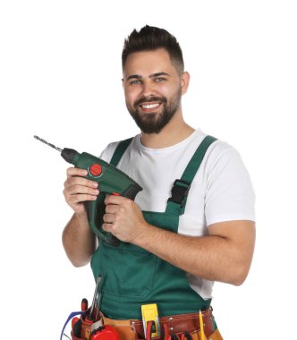 Beyaz arka planda matkabı olan üniformalı genç bir işçi.