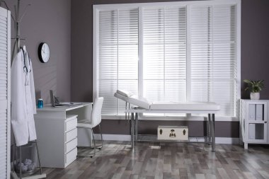 Doktorun çalışma alanı ve muayene masası olan modern tıp bürosu