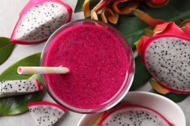 Lezzetli pitahaya smoothie ve açık gri masada taze meyveler, düz uzanma