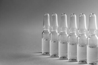 Pharmaceutical ampoules with medication on light grey background. Space for text