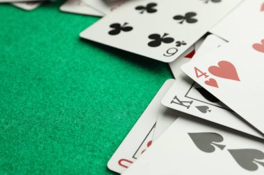 Yeşil masaya dağılmış iskambil kağıtları, yakın plan. Metin için boşluk