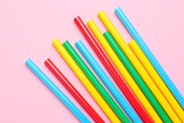Pembe arka planda bir sürü renkli yapıştırıcı var.