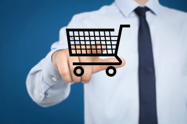Mavi arka planda alışveriş arabasının sanal görüntüsünü gösteren bir adam.