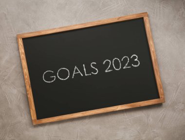 Açık gri taş zemin üzerinde hedef 2023 tabirli karatahta, üst görünüm