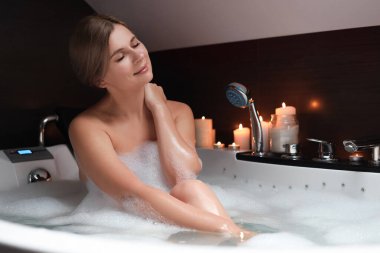 İçeride köpük banyosu yapan güzel bir kadın. Romantik atmosfer