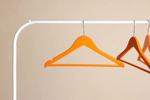 Оранжевая Одежда Висит Металлической Стойке Бежевом Фоне — стоковое фото