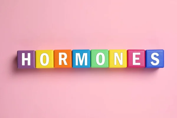 Word Hormonen Gemaakt Van Kleurrijke Blokjes Met Letters Roze Achtergrond — Stockfoto