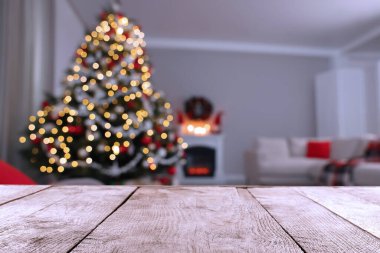 Şöminenin yanında Noel ağacı olan şenlikli odada boş ahşap masa. Tasarım için boşluk
