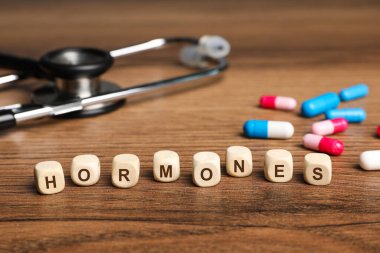 Harflerle, steteskopla ve ahşap masadaki haplarla yapılmış kelime hormonları.