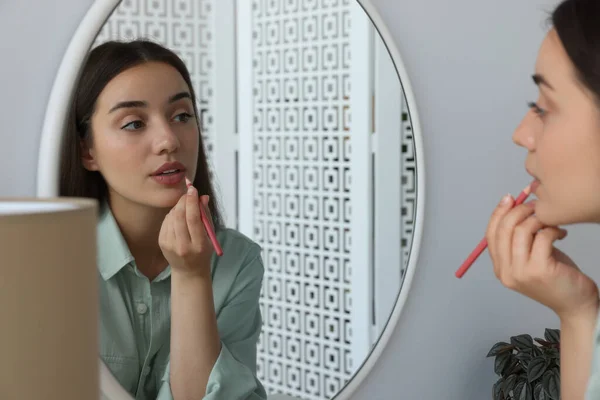 Mulher Nova Bonita Que Aplica Lápis Cosmético Lábios Perto Espelho — Fotografia de Stock