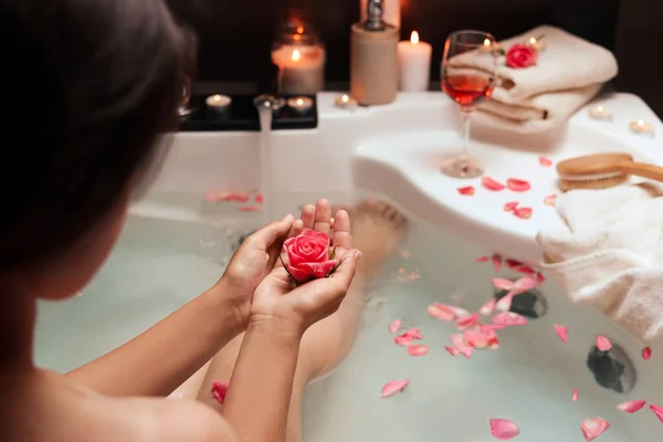 風呂に入っている間にバラの花を持っている女性 ロマンチックな雰囲気 — ストック写真
