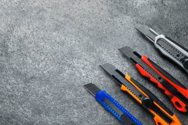 Gri masada farklı kullanım bıçakları var, düz yerde. Metin için boşluk