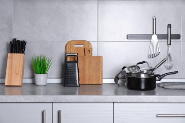 Gri tezgahta mutfak gereçleri ve yemek takımları